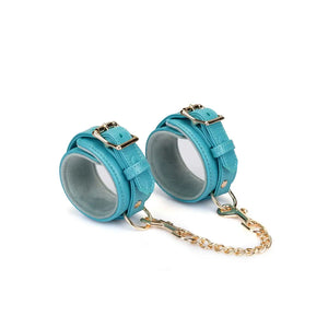 Menottes Agneau Bleu LIEBE SEELE en cuir bleu doublé agneau clair avec fermeture réglable, anneaux métalliques et chaîne dorée, photographiées sur fond blanc