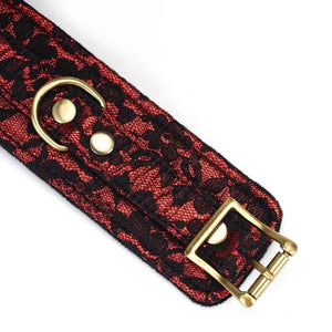 Menottes de bondage Victorian Garden en cuir vegan rouge et dentelle noire, avec doublure en fausse fourrure et détails dorés. Confortables, ajustables et reliées par une chaîne détachable.