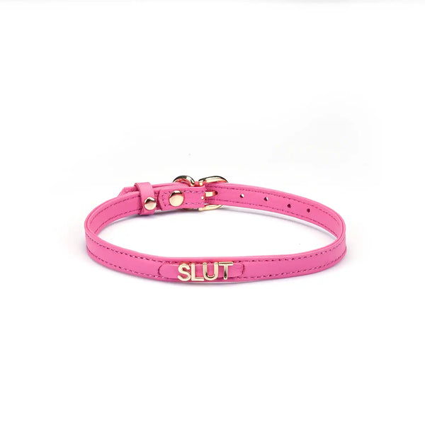 Collier en cuir rose de la marque Liebe Seele, orné d’une inscription métallique Slut et de finitions dorées, présenté sur fond clair dans l’univers Brigade Mondaine Paris.