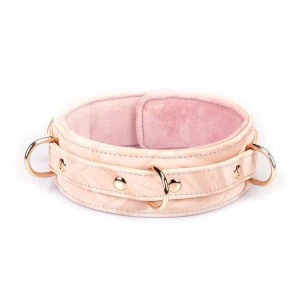 Collier de bondage Pink Boudoir Amor en similicuir vegan rose et noir. Finitions dorées, trois anneaux en D pour fixation. Avec laisse en chaîne dorée, élégant et ajustable pour une domination raffinée.