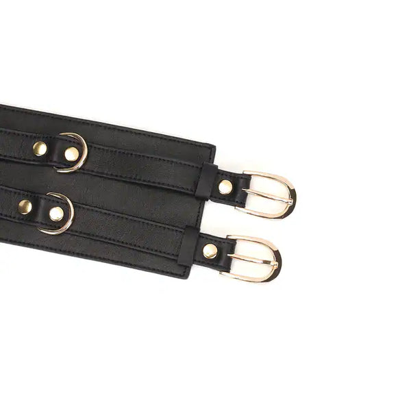 Ceinture de bondage en cuir noir de la collection Dark Secret. Fabriquée à la main avec des finitions dorées et deux anneaux en D pour fixation. Accessoire de domination luxueux et raffiné.