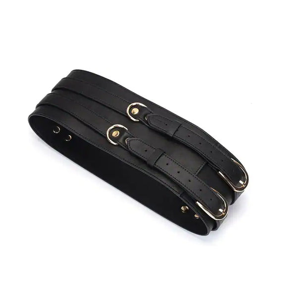 Ceinture de bondage en cuir noir de la collection Dark Secret. Fabriquée à la main avec des finitions dorées et deux anneaux en D pour fixation. Accessoire de domination luxueux et raffiné.