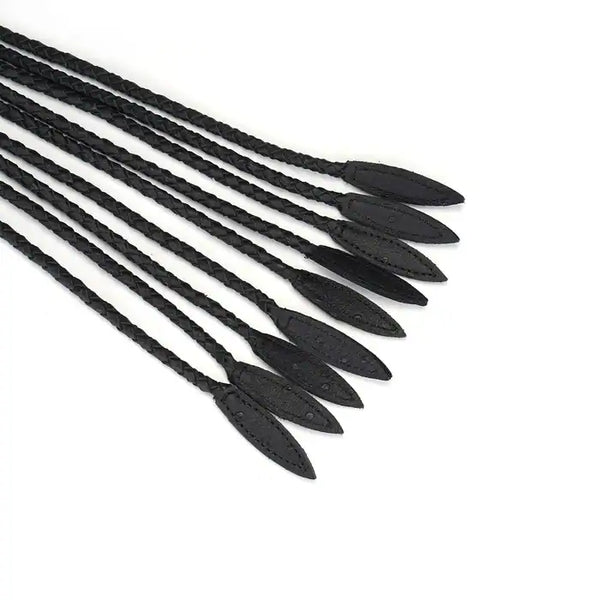 Fouet à neuf queues en cuir noir tressé avec pointes de cuir. Accessoire BDSM léger et maniable, avec prise ferme et boucle de suspension discrète.