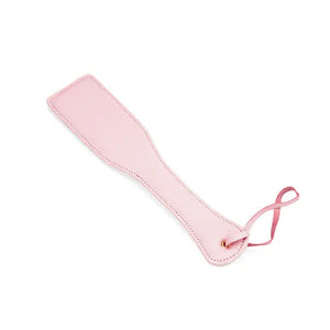 Paddle en cuir rose de la collection Fairy, confectionné en cuir d'agneau blanc et rose avec accents or rose. Un accessoire BDSM raffiné pour des jeux de fessée contrôlés et élégants.