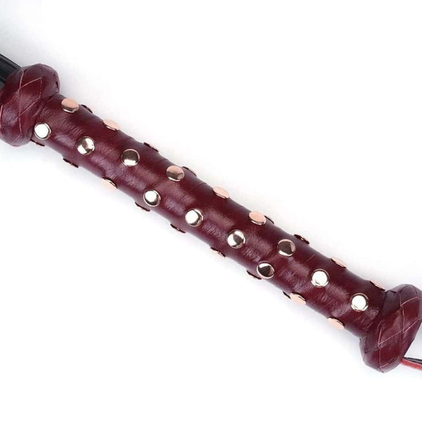 Détail du Packshot d'un Martinet avec un Manche en Cuir Rouge et Lanières en Cuir Noir