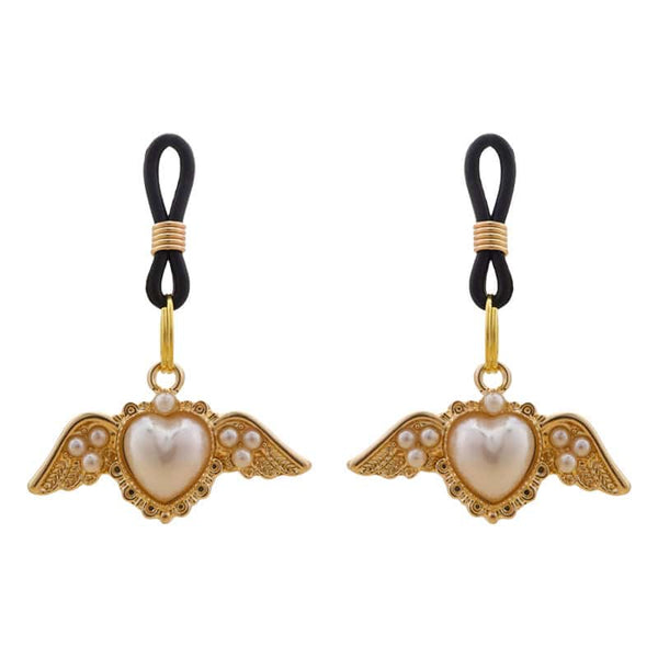 Pinces pour tétons Angel de la marque Liebe Seele, ornées de cœurs ailés dorés et de perles, reliées par des attaches noires, présentées sur fond clair dans l’univers Brigade Mondaine Paris.