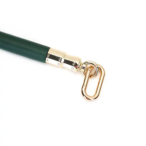 Barre d'écartement en cuir vert et bois d'eucalyptus, avec attaches métalliques dorées. Accessoire BDSM élégant pour une immobilisation précise et contrôlée, parfait pour la collection Mossy Chic.