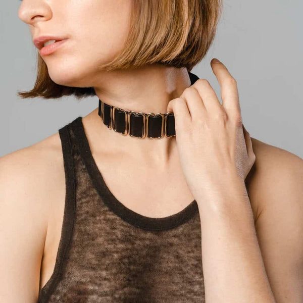 Modèle portant le Bulletproof Choker noir Perlensau avec plaques métalliques dorées articulées, proposé par Brigade Mondaine Paris.