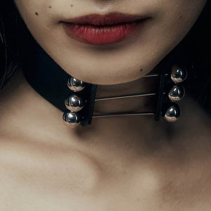 Trinity Choker Perlensau en cuir noir avec barres métalliques et sphères argentées, proposé par Brigade Mondaine Paris.