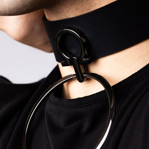 Modèle portant le choker Divine Perlensau en cuir noir avec large anneau métallique suspendu, proposé par Brigade Mondaine Paris.
