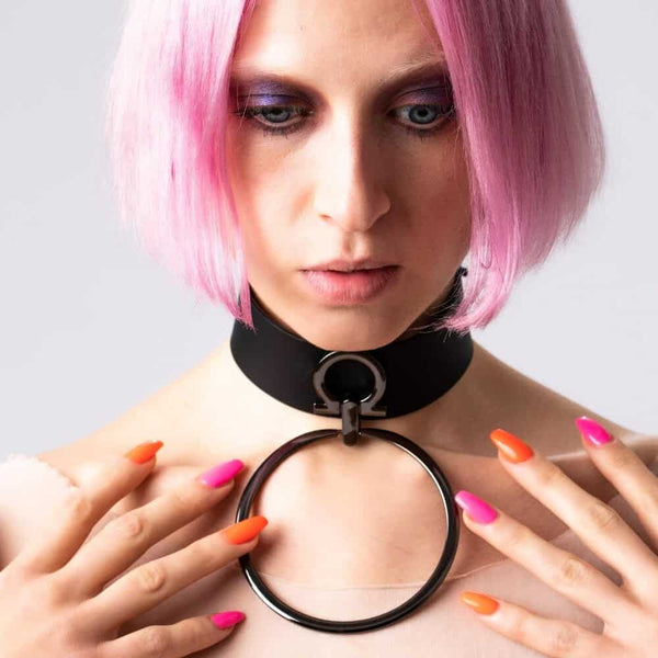 Modèle portant le choker Divine Perlensau en cuir noir avec large anneau métallique suspendu, proposé par Brigade Mondaine Paris.