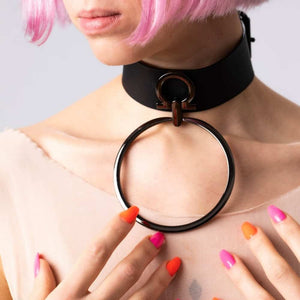 Modèle portant le choker Divine Perlensau en cuir noir avec large anneau métallique suspendu, proposé par Brigade Mondaine Paris.