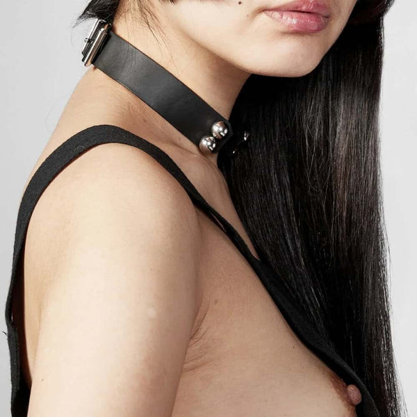 Modèle portant le Industrial Choker Perlensau en cuir noir avec éléments métalliques argentés, proposé par Brigade Mondaine Paris.