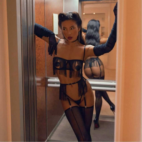Lingerie Olivia en tulle avec franges longues et détails réglables. Soutien-gorge ouvert, micro string, harnais porte-jarretelles et choker assorti. Style minimaliste et dynamique signé Pivovarova. Silhouette graphique et fluide. Pièces fabriquées à la main.