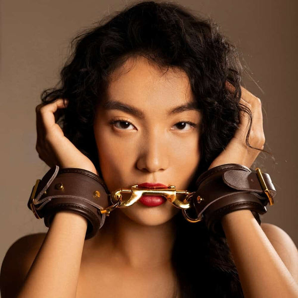 Menottes de poignets UPKO en cuir brun avec boucles et rivets en métal doré, sélection Brigade Mondaine Paris