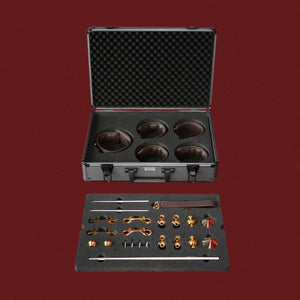 Coffret complet d’accessoires BDSM en cuir et métal doré présenté dans une mallette rigide Brigade Mondaine Paris