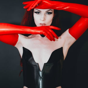 Mannequin portant le corset Nyx en cuir rouge RE:STRICT chez Brigade Mondaine Paris, décolleté structuré, porté avec collier assorti et accessoires noirs, photographié en studio.