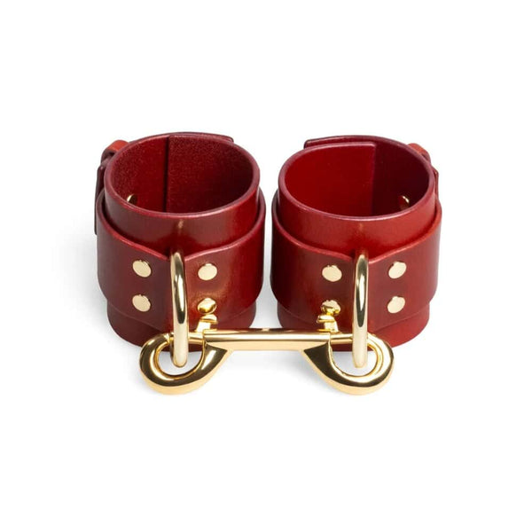 Menottes en cuir rouge ajustables avec D-ring et lien métallique doré création bondage minimaliste et artisanale signée RE:STRICT
