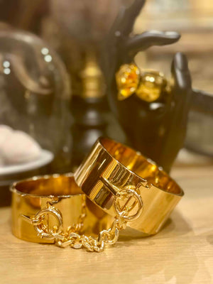 menottes bracelets dorées posées sur un meuble en bois
