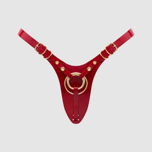 Harnais de pegging STRAP-ON-ME en cuir rouge avec anneau central doré et sangles réglables, sélection Brigade Mondaine Paris.