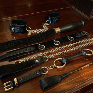 Collection de bondage composée de menottes, d'un fouet sextoy, d'un chocker, d'une laisse, d'un gag et d'une cravache