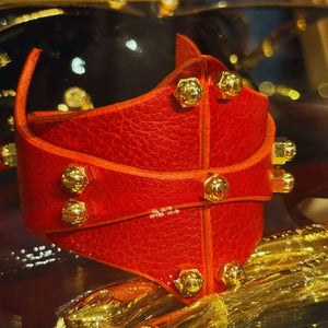 Bracelet Horizontal en cuir Rouge Cherry signé Úna Burke, avec raccords en laiton massif recouverts d'or et vis en laiton, alliant esthétique rock chic et bondage pour une touche d'élégance audacieuse.
