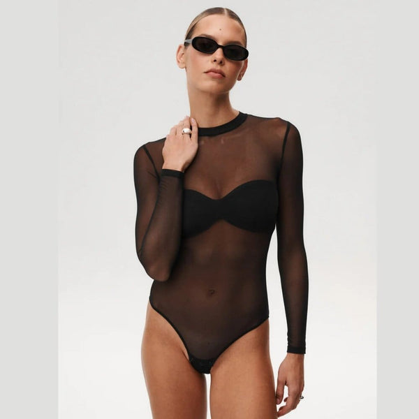 Body noir transparent Undress Code Stay Simple porté par un modèle, coupe minimaliste et manches longues, sélection Brigade Mondaine Paris.