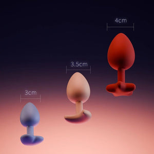 Accessoires anaux UPKO en silicone de différentes tailles 3 cm 3.5 cm et 4 cm présentés sur fond dégradé Brigade Mondaine Paris