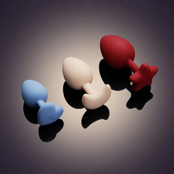 Accessoires anaux UPKO en silicone de différentes tailles 3 cm 3.5 cm et 4 cm présentés sur fond dégradé Brigade Mondaine Paris