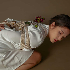 Corde Shibari de couleur crème de la marque UPKO. Le mannequin porte un entrelacement de cordes d'une longueur de 10 m et d'un diamètre de cordon de 6mm.