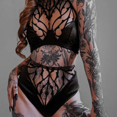 Vue d’un ensemble lingerie DOGMA composé d’un soutien-gorge à col licou en tulle nude brodé noir avec perles, associé à une culotte taille haute en tulle nude et satin noir vegan, illustrant l’alliance entre architecture gothique et élégance contemporaine.