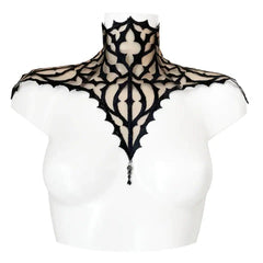 Plastron gothique brodé noir sur tulle nude, orné d’un pendentif central. Forme montante couvrant cou et épaules. Fermeture réglable par ruban façon corset au dos.