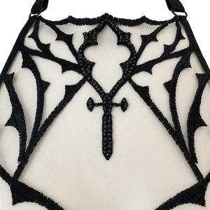 Soutien-gorge gothique en tulle nude brodé noir avec perles facettées. Demi-bonnets en satin noir doublé et col licou réglable. Élégance dramatique et maintien confortable.