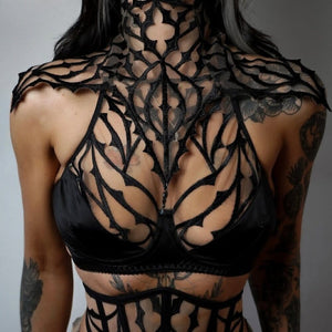 Collier Dogma noir en dentelle graphique VIDE NOIR porté chez Brigade Mondaine Paris, encolure haute, motifs ajourés architecturaux et finition délicate, photographié en intérieur.