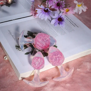 Plug en silicone rose LIEBE SEELE avec surface spiralée et base transparente évasée, tenu en main sur fond blanc, vue produit détaillée