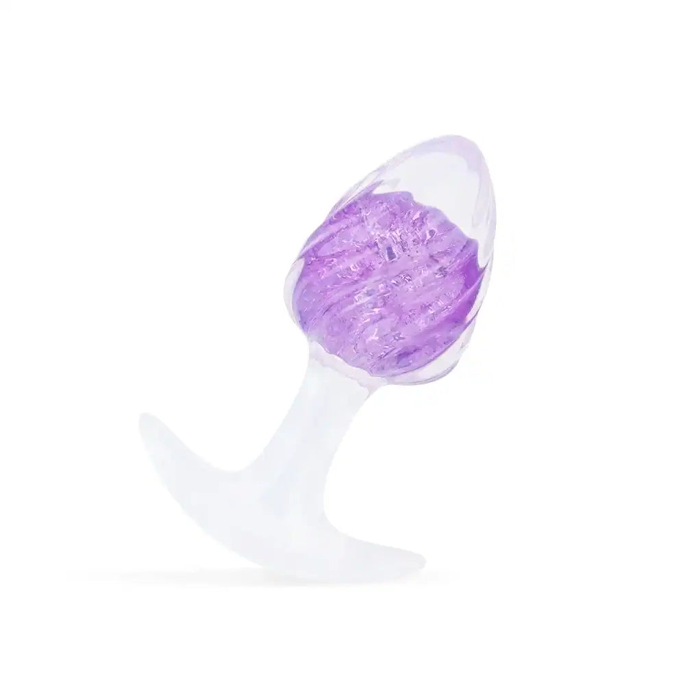 Plug en silicone violet LIEBE SEELE avec surface spiralée et base transparente évasée, tenu en main sur fond blanc, vue produit détaillée
