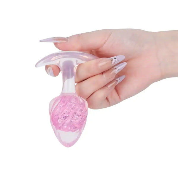 Plug en silicone rose LIEBE SEELE avec surface spiralée et base transparente évasée, tenu en main sur fond blanc, vue produit détaillée