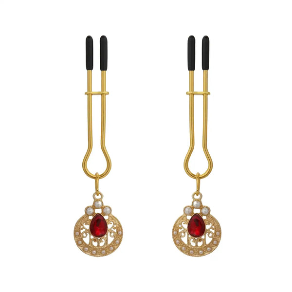Pinces à tétons chaînes perles de la marque Liebe Seele, composées de pinces dorées reliées par une chaîne de perles blanches avec ornements sertis, présentées sur fond clair dans l’univers Brigade Mondaine Paris.