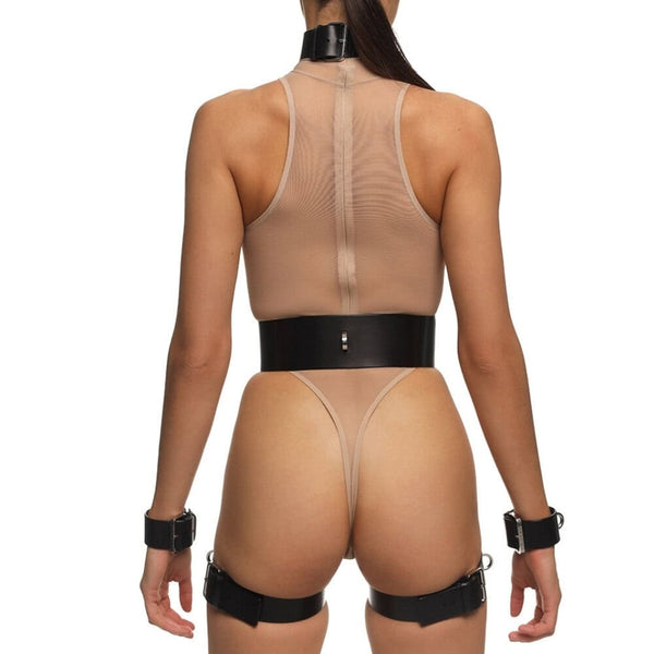 Full Set REVNA signé Anoeses : ensemble bondage en cuir noir avec harnais, collier, ceinture et menottes de cuisse reliées par des sangles – silhouette graphique et fétiche au style affirmé.