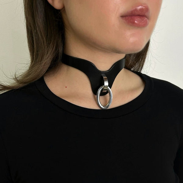 Collier choker en cuir noir avec anneau métallique argenté et boucle de fermeture.