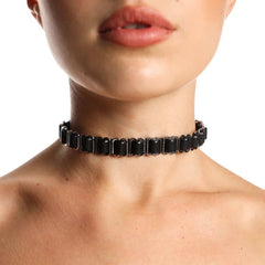 Choker ANOESES noir porté autour du cou d’un modèle féminin, composé d’anneaux métalliques alignés et d’une structure ajustable, esthétique fétiche haut de gamme Brigade Mondaine Paris.