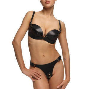 Soutien-gorge ANOESIS en cuir noir avec armatures, sangles réglables et finitions métalliques dorées, porté avec un string assorti sur fond blanc.