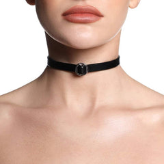 Collier ANOESES en cuir noir présenté à plat, bande fine avec anneau métallique central et fermeture réglable à boutons-pression, esthétique fétiche haut de gamme Brigade Mondaine Paris.
