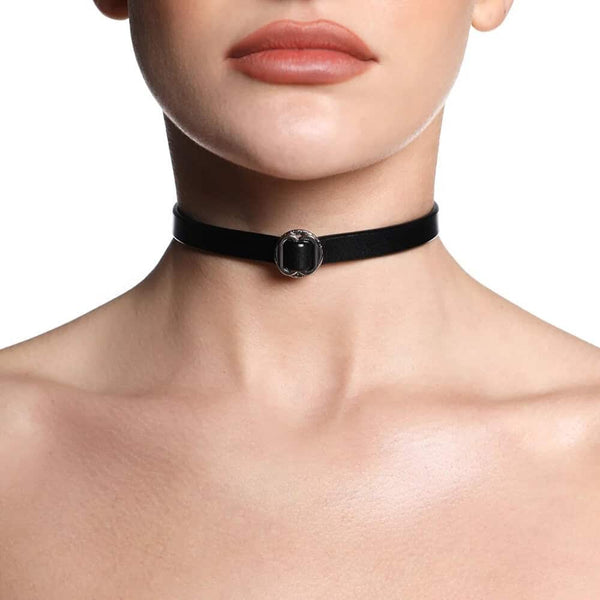 Collier ANOESES en cuir noir présenté à plat, bande fine avec anneau métallique central et fermeture réglable à boutons-pression, esthétique fétiche haut de gamme Brigade Mondaine Paris.