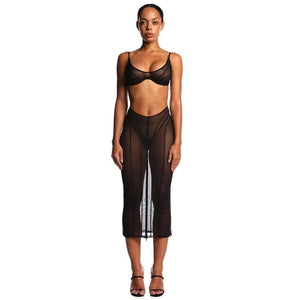 Ensemble ANOESES composé d’une jupe fendue et d’un soutien-gorge en tulle noir, porté par un modèle féminin debout, coupe ajustée, fente centrale et lignes verticales structurées, esthétique fétiche haut de gamme Brigade Mondaine Paris.