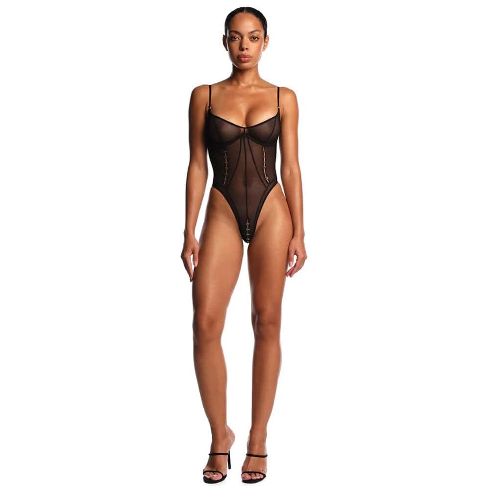 Body en tulle noir ANOESES porté par un modèle féminin allongé, découpes latérales, lacets décoratifs sur le buste, porté avec bas noirs et col assorti, esthétique fétiche haut de gamme Brigade Mondaine Paris.