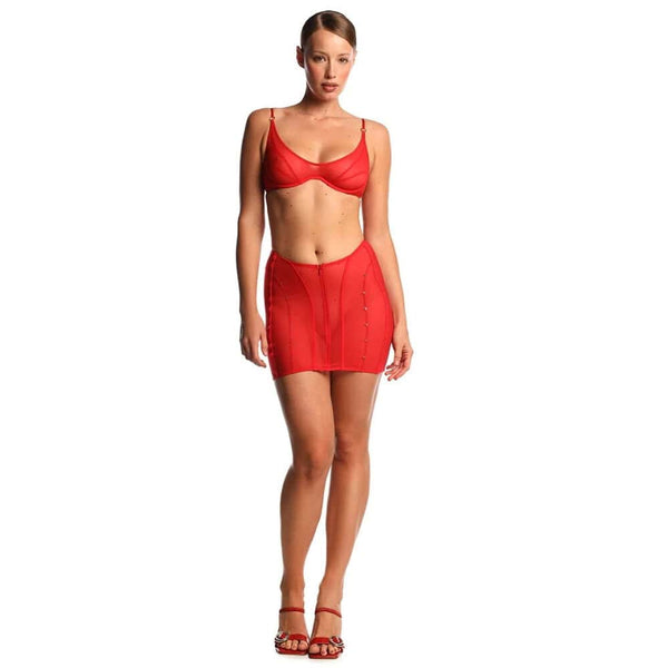Ensemble ANOESES composé d’un soutien-gorge et d’une jupe en tulle rouge, porté par un modèle féminin debout, coupe ajustée, lignes structurées et détails graphiques, esthétique fétiche haut de gamme Brigade Mondaine Paris.