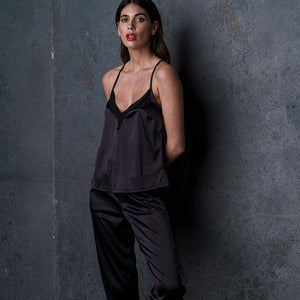 Le pantalon satin Nuit à Broadway porté par une femme, avec une ceinture froncée pour un confort optimal. Ses poches plaquées et ses bandes latérales lui donnent un look moderne et raffiné, idéal pour un ensemble homewear sexy.