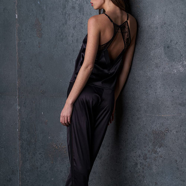 Le pantalon satin Nuit à Broadway porté par une femme, avec une ceinture froncée pour un confort optimal. Ses poches plaquées et ses bandes latérales lui donnent un look moderne et raffiné, idéal pour un ensemble homewear sexy.