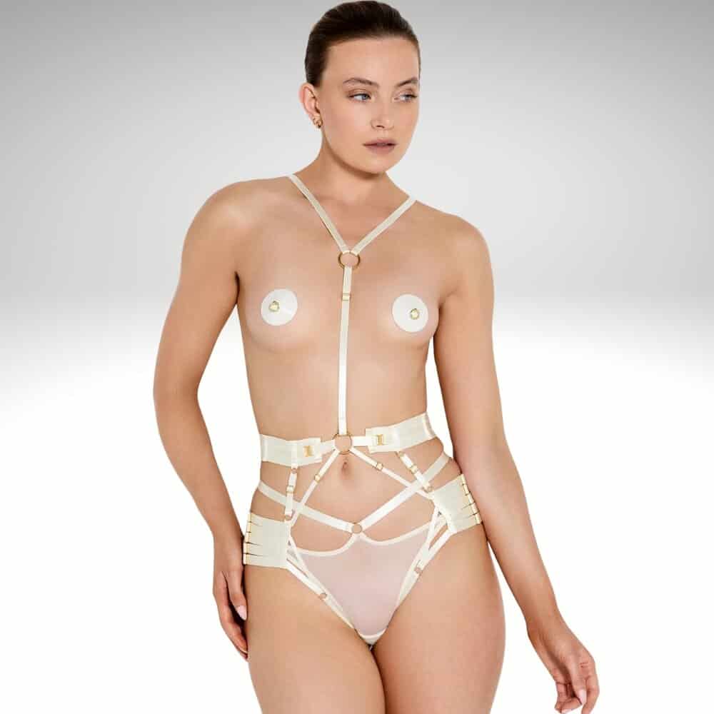Harnais corps modulable crème BORDELLE porté de face, sangles elastiques ajustables et anneaux dorés soulignant la silhouette.